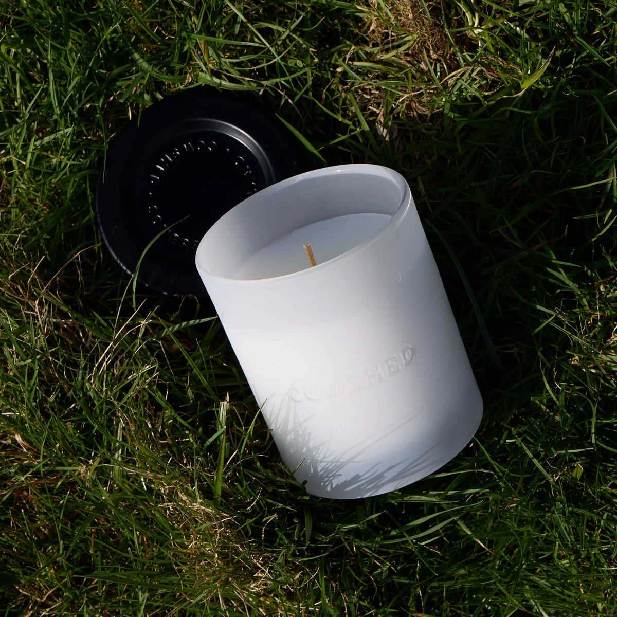 Cowshed candle with a lid on grass