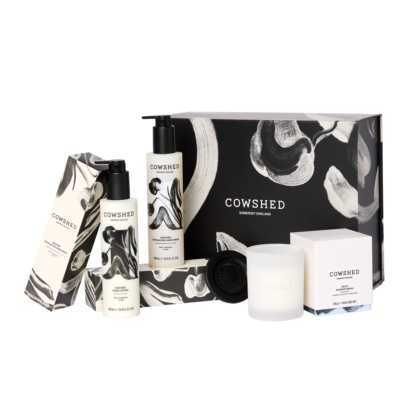 Cowshed product set including bottles, a candle, and a box on a white background