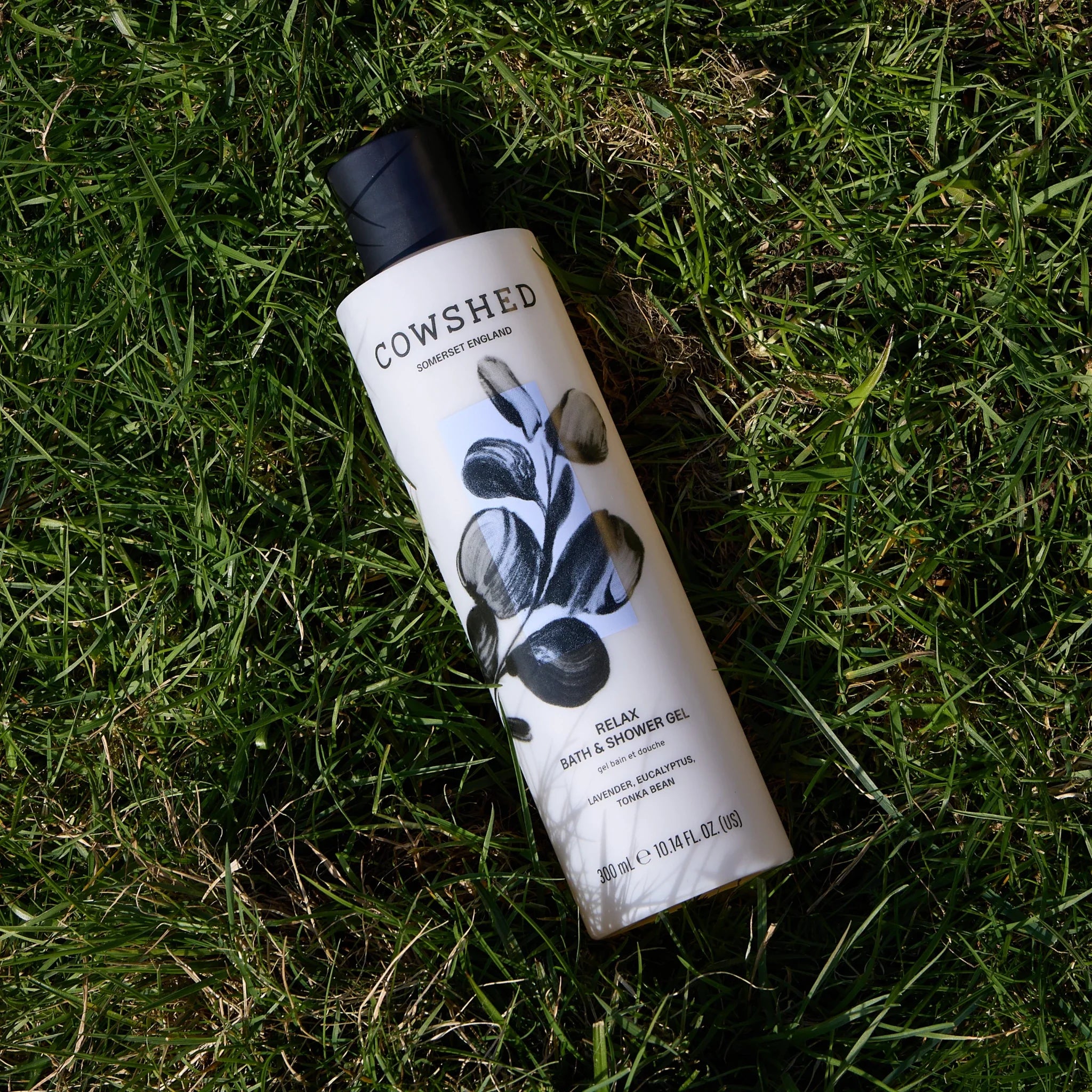 Cowshed Relax shower gel lavender & eucalyptus bottle on grass