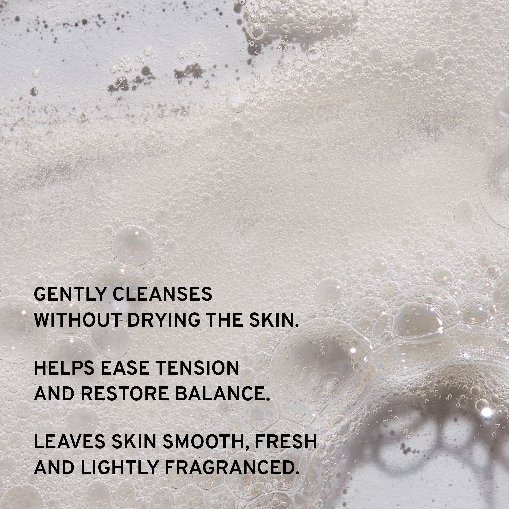 Foamy liquid with bubbles and text describing skincare benefits of cowshed shower gel on a light background