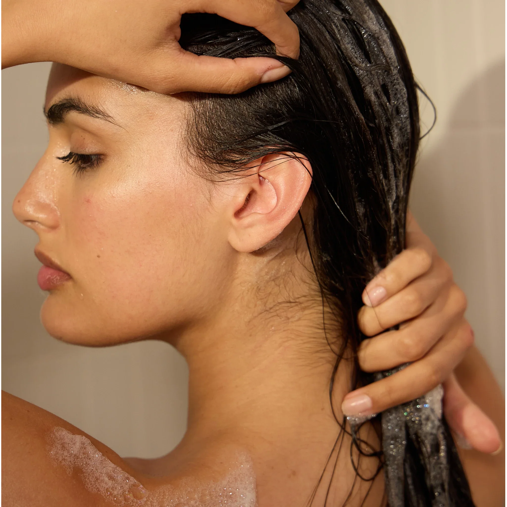 Woman washing her hair with Cowshed Soften shampoo
