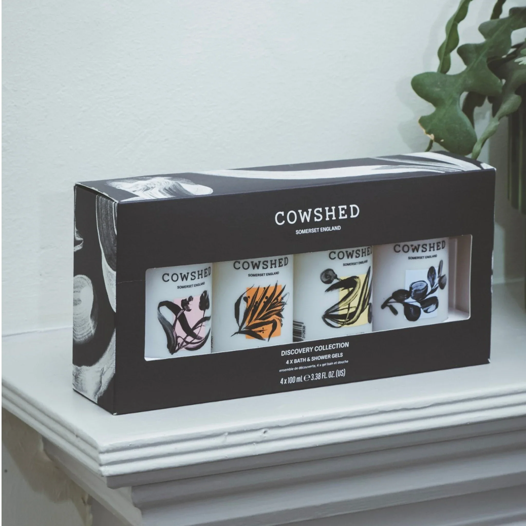 Cowshed product set packaging on a white surface with a plant in the background