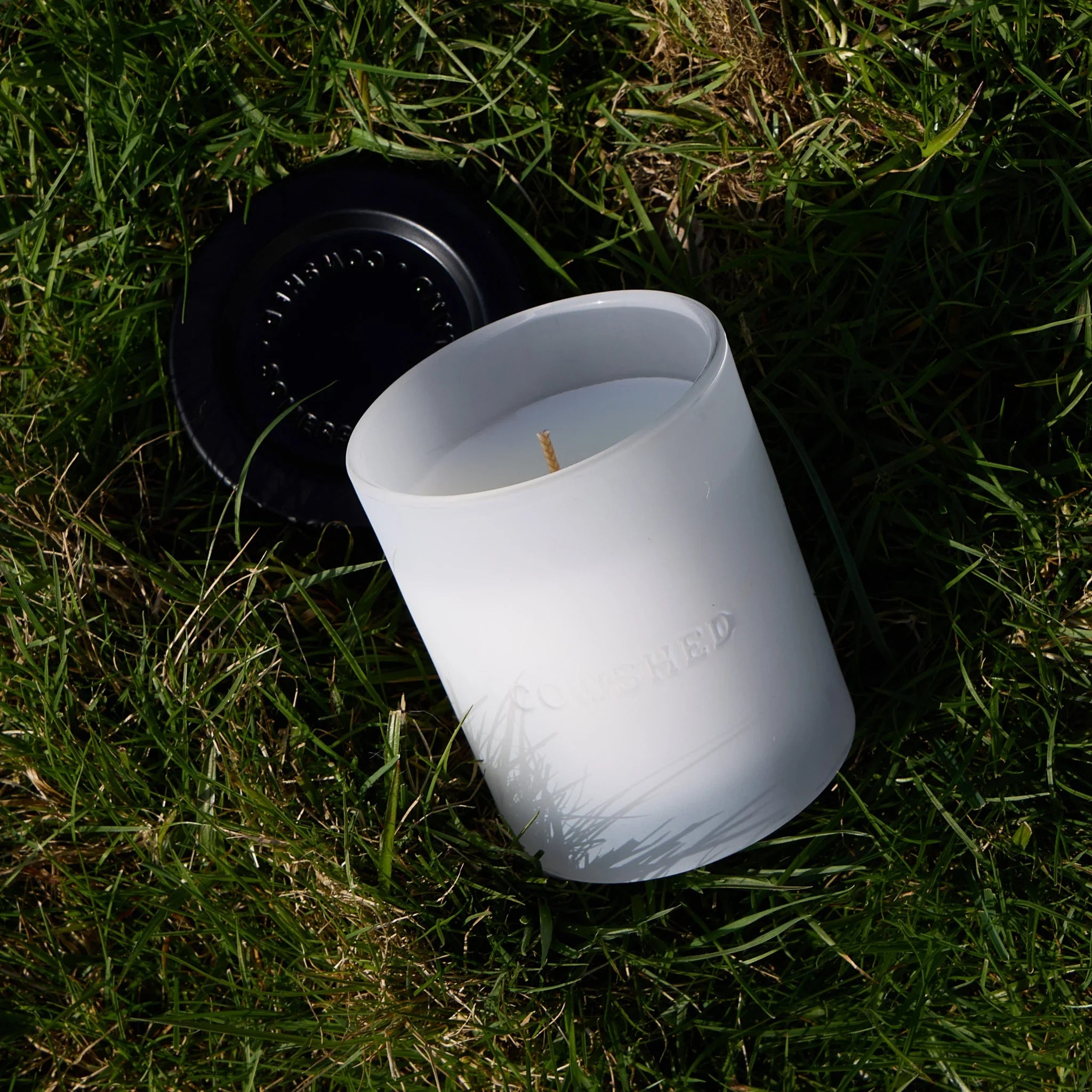 Cowshed candle with a lid on grass