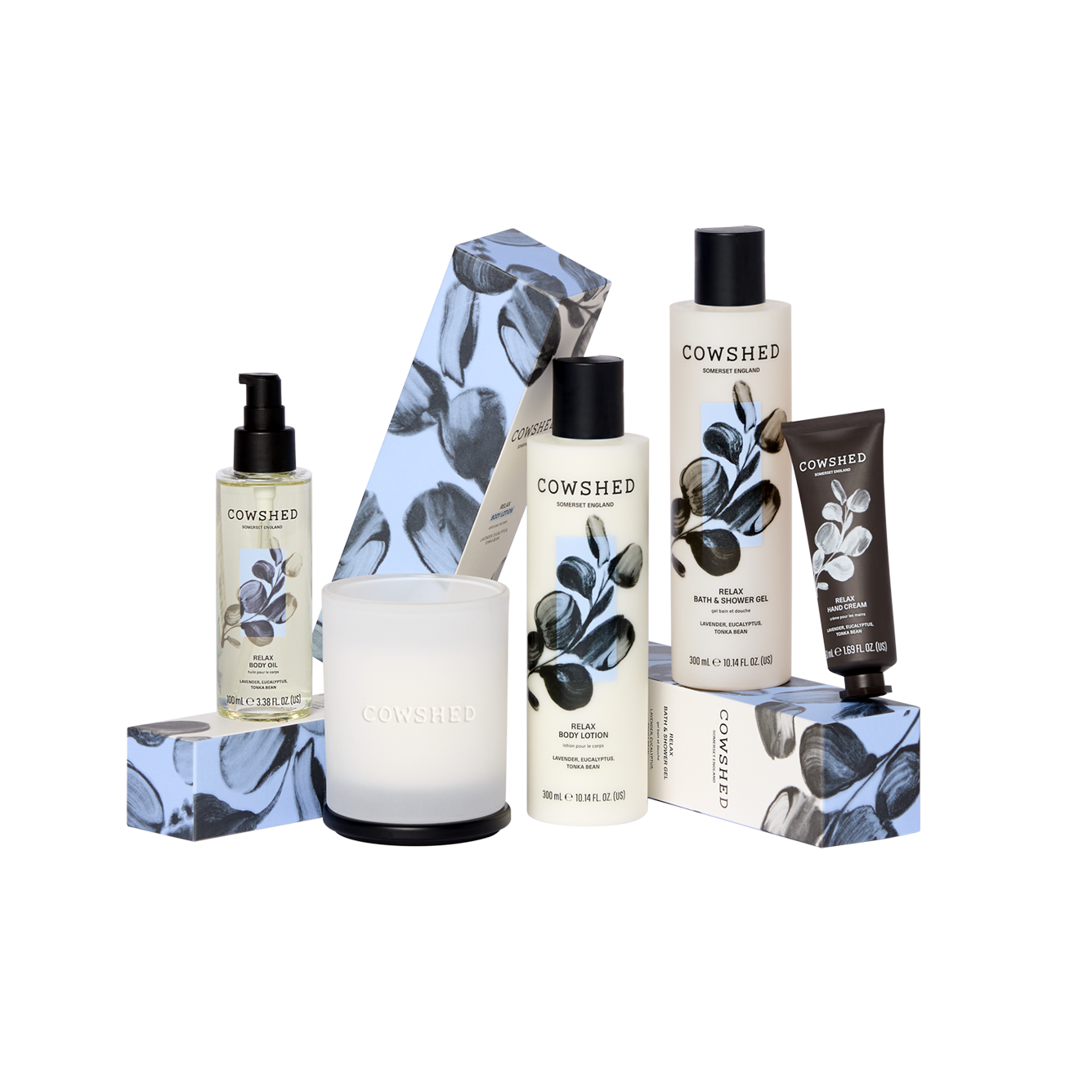 Cowshed product set including bottles, a candle, and a box on a white background