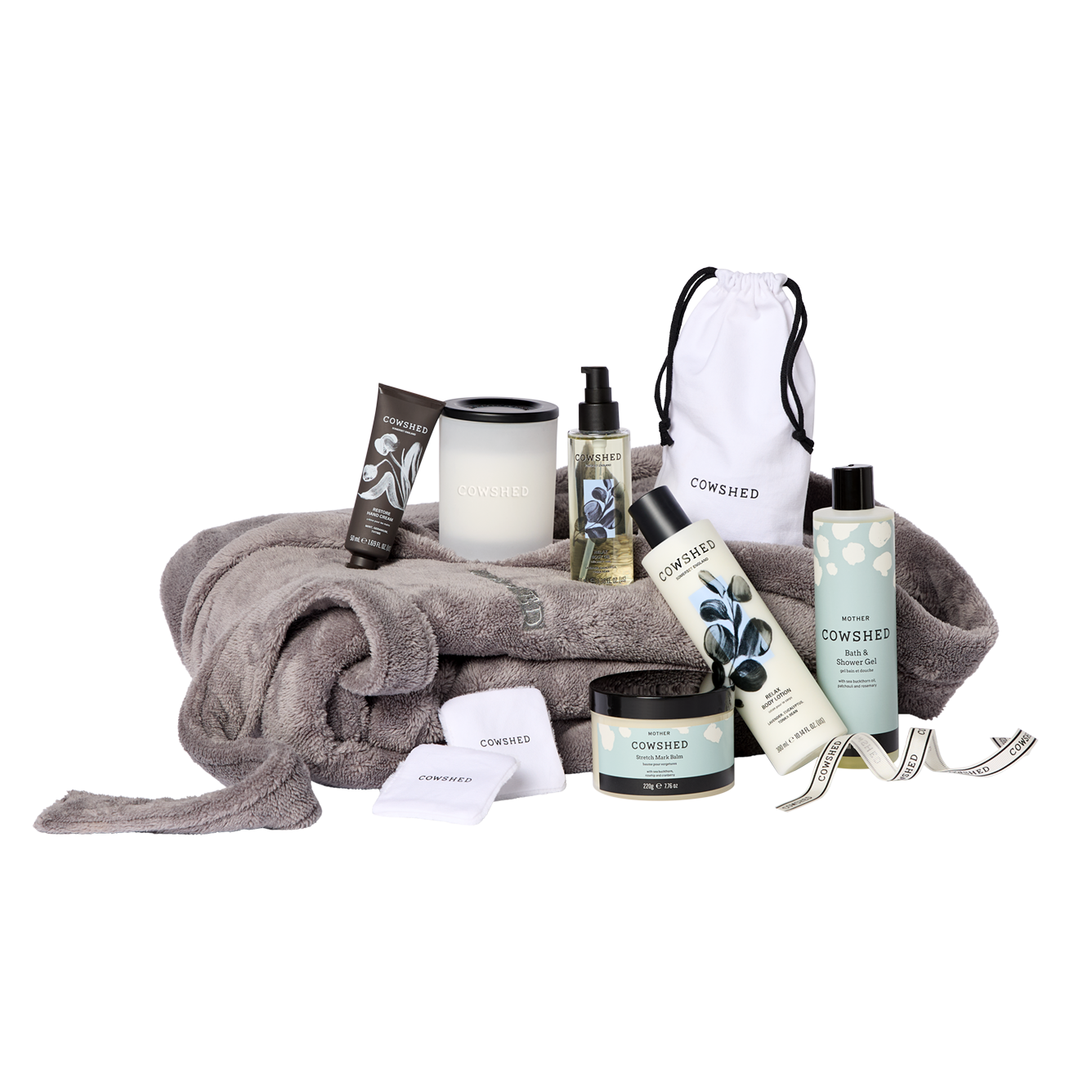 Cowshed bath and body products including a towel, candles, and bottles on a white background